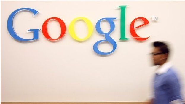 Man walks past Google sign