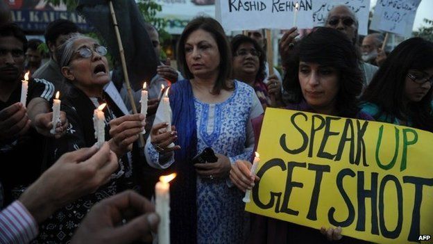 Activists of Human Rights Commission of Pakistan (HRCP) hold candles and placards as they shout slogans during a protest against the killing of Pakistani lawyer Rashid Rehman in Islamabad on May 8, 2014.