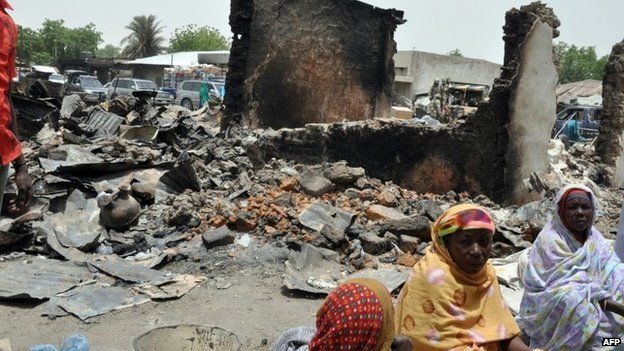 Women sit at Gamboru central market on 11 May 2014 burnt by suspected Boko Haram insurgents during the 5 May attack at Ngala in Gamboru Ngala district, Borno State in north-eastern Nigeria