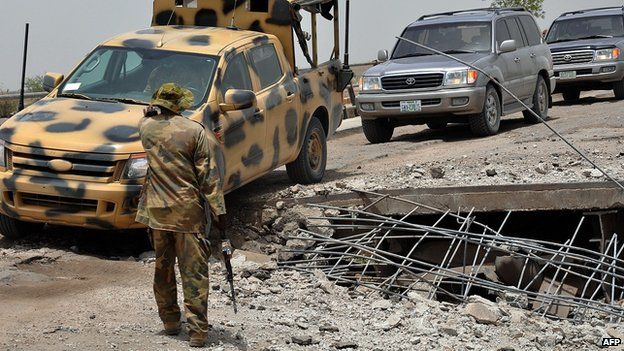 A soldier directs the way to a military truck navigating through a link bridge at Ngala connecting Nigeria and Cameroon which was destroyed by suspected Boko Haram insurgents during last Monday"s attack at Ngala in Gamboru