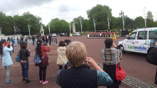 The BBC's China Editor Carrie Gracie photographs tourists snapping soldiers marching past Buckingham palace