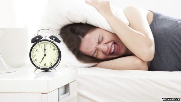 Alarm clock waking woman