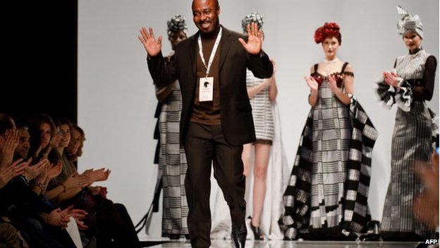 Ghanaian designer Kofi Ansah salutes at the end of his show in Rome, February 2009