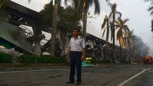 Security guard stands beside a burnt-out Chinese-owned shoe factory in Binh Duong province on 14 May 2014