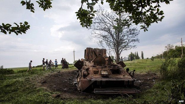 Youths look at a destroyed Ukrainian army vehicle near Kramatorsk in eastern Ukraine - 14 May 2014