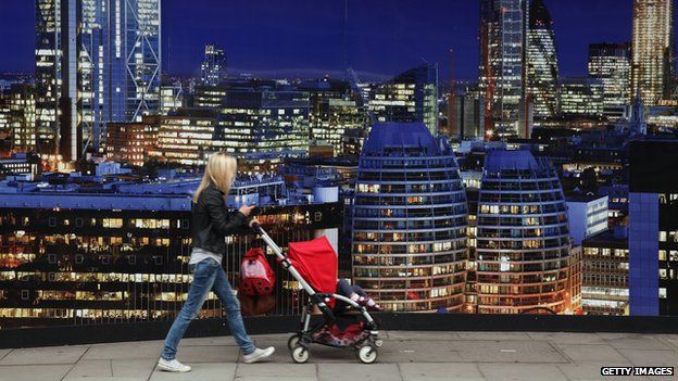 A woman walks by a luxury development advertisement in London