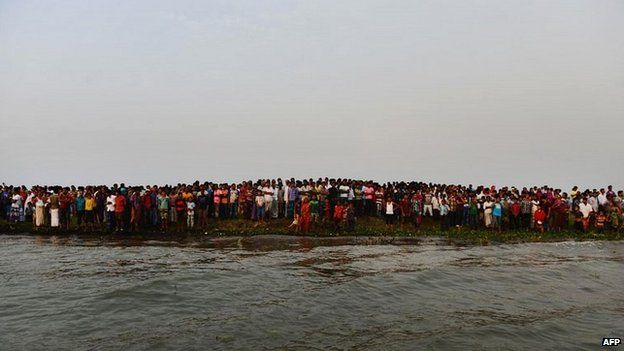 Local residents gather on the bank of the Meghna river to await news of the missing passengers - 15 May 2014