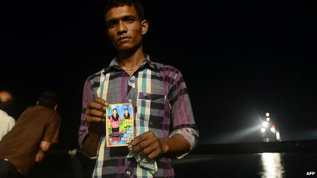 A relative holds a photograph of his missing niece as rescue workers continue the search for survivors - 15 May 2014