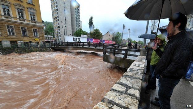 Residents of Sarajevo look at the river Miljacka on 14 May 2014
