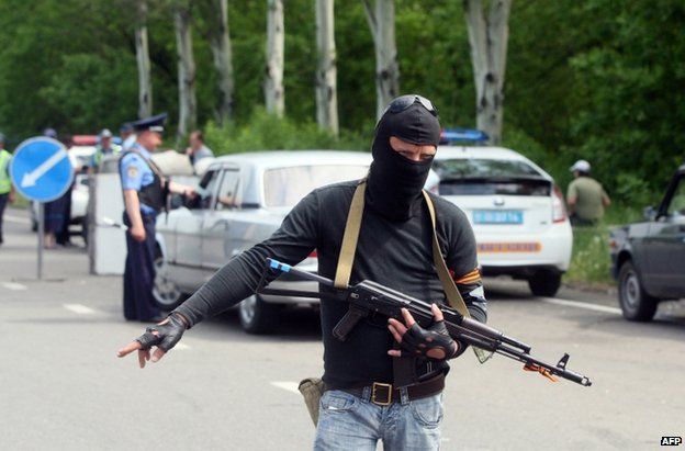 A pro-Russian militant mans a checkpoint along with a police officer near Donetsk, 15 May