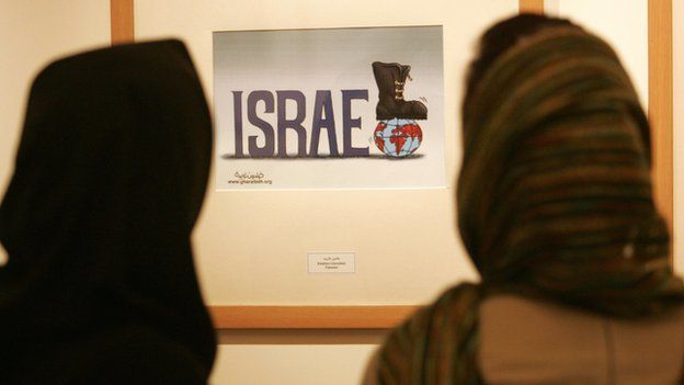 Iranian women look at anti-Israel cartoon in Tehran (file photo)