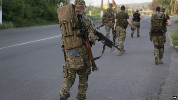 Pro-Russian militants walk to their positions to fight against Ukrainian government troops outside Sloviansk, eastern Ukraine, 17 May