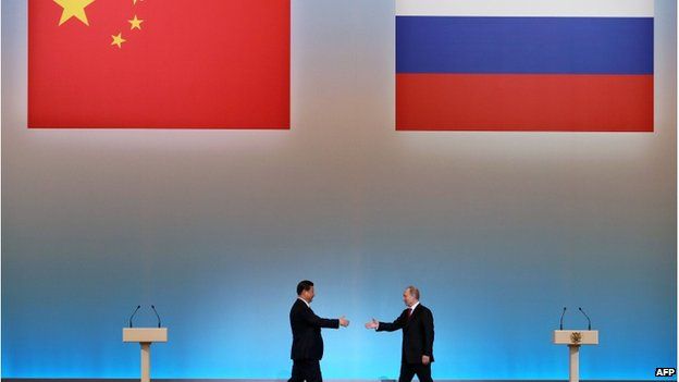 China's President Xi Jinping (L) is welcomed by his Russian counterpart Vladimir Putin (R) during the opening ceremony of "The Year of Chinese Tourism in Russia" in Moscow, on 22 March, 2013