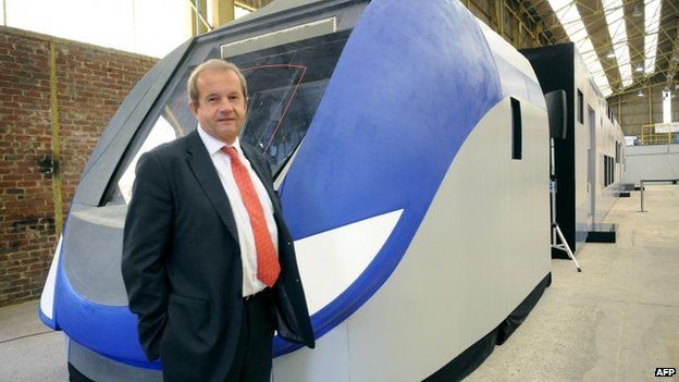 Bombardier Transportation in France head Jean Berge stands in front of a giant model of the "Regio 2N" regional double-deck train developed for the French SNCF railway network