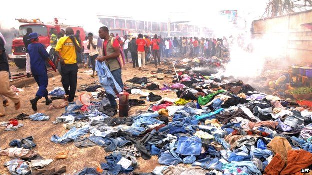Stallkeepers salvage their belongings as rescuers and residents gather at the charred scene following a bomb blast at Terminus market in the central city of Jos (20 May 2014)