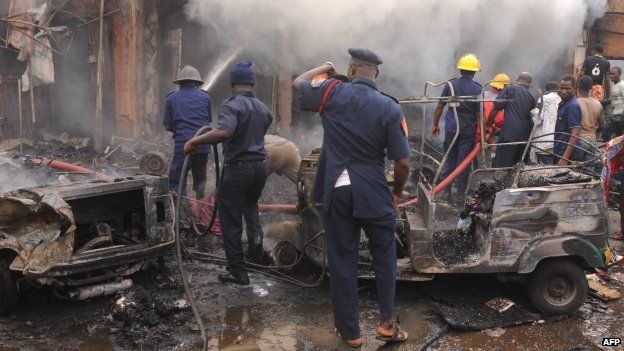 Firefighters extinguish a fire at the scene of a bomb blast at Terminus market in the central city of Jos (20 May 2014)