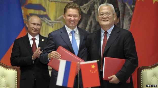 Gazprom CEO Alexei Miller and CNPC Chairman Zhou shake hands with Russian President Putin