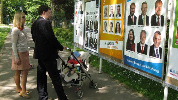 Luxembourgers looking at election posters