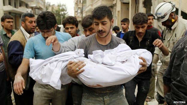 A man carries a dead body after what activists said was a barrel bomb attack by government forces on Aleppo - 25 April 2014