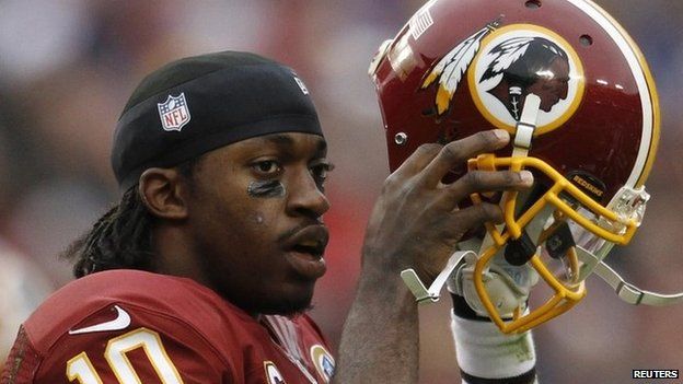 Washington Redskins quarterback Robert Griffin III puts his helmet back on after being tackled by the Baltimore Ravens defence in the first half of their NFL football game in Landover, Maryland 9 December 2012