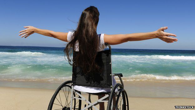 Woman in wheelchair on beach