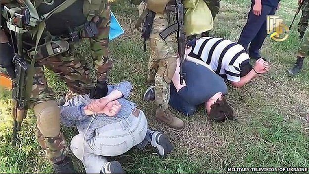 Reporters working for Russian media in Ukraine kneel as Ukrainian security services point guns at them