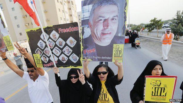 Protesters hold banners with photo of Nabeel Rajab asking for their release in Al A"ali south of Manama, on 18 April2014.