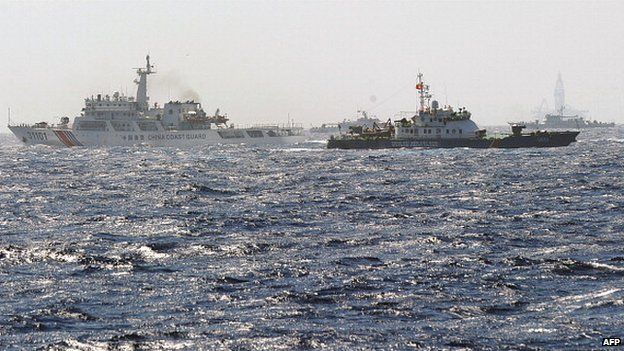 This picture taken from a Vietnam Coast Guard ship on 14 May shows a Vietnam Coast Guard ship (2nd R, dark blue) trying to make way amongst several China Coast Guard ships near to the site of a Chinese drilling oil rig (R, background) being installed at the disputed water in the South China Sea off Vietnam's central coast.