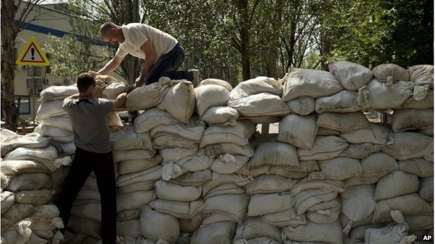 Residents build a sandbag shooting position on the road to the airport in Donetsk (27 May 2014)