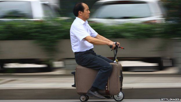 He Liang rides his motorised suitcase