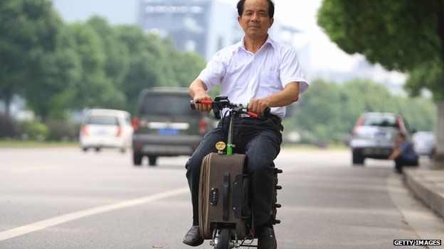 He Liang rides his motorised suitcase