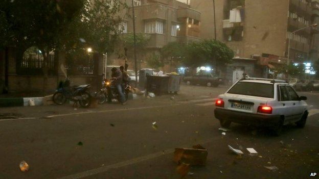 A motorbike and a car, seen through the window of a car, are stopped in a street in Tehran, Iran, 2 June 2014