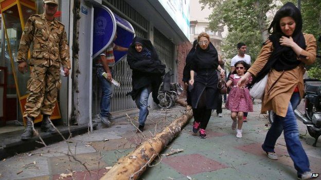 Pedestrians make their way on a sidewalk of Tehran, Iran, 2 June 2014