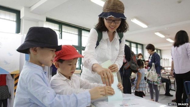 South Koreans cast their votes in a polling station on 4 June 2014 in Seoul, South Korea