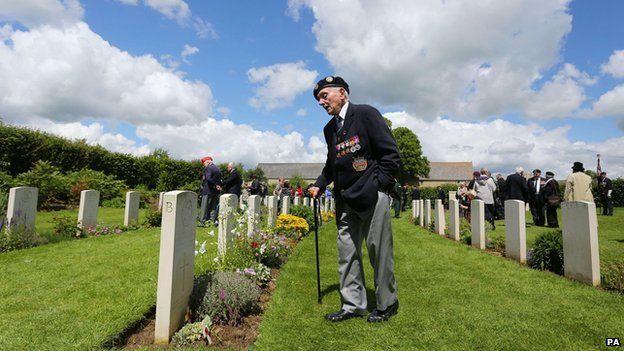 A member of the Normandy Veterans Association views headstones at Jerusalem Cemetery in Chouain, France, on 4 June 2014 at a commemorative ceremony to mark 70th anniversary of the D-Day landings