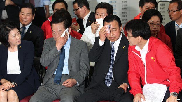 Ли Ван Гу, лидер правящей партии Саэнури, и Со Чон Вон, председатель избирательной кампании партии, вытирают пот со своих лиц, когда смотрят телевизионную программу, транслирующую предвыборные экзитполы в Сеуле, Южная Корея, в среду. , 4 июня 2014 г.