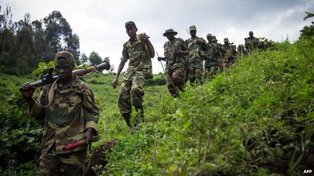 M23 rebels withdraw through the hills after leaving their position in the village of Karuba, eastern Democratic Republic of Congo, on 30 November 2012