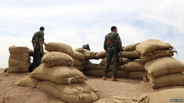 Members of the Kurdish People's Protection Units (YPG) stand guard in the Kurdish town of al-Qahtaniya of Hassakeh province on 11 May 2014