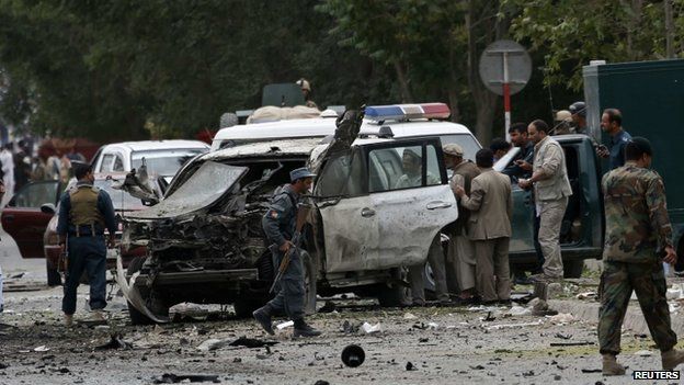 Afghan policemen investigate the site of a suicide attack in Kabul June 6, 2014.