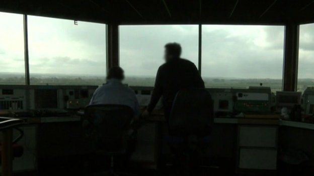 Staff in silhouette in air traffic control room
