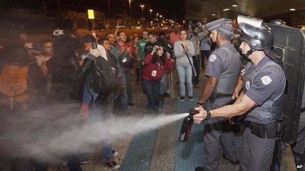 A police officer pepper sprays strikers and protesters during a clash with riot police in front of the Ana Rosa metro station, in an ongoing subway strike by operators in Sao Paulo, Brazil, on 9 June 9, 2014