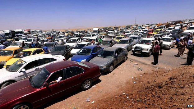 Iraqis fleeing violence in the Nineveh province sit in a traffic jam outside Erbil - 10 June 2014