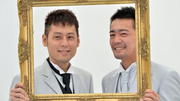 A gay couple poses for photos taken by a wedding photo service company in Tokyo on 27 April, 2014