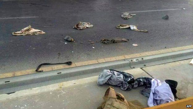 A picture taken with a mobile phone shows uniforms reportedly belonging to Iraqi security forces scattered on the road on June 10, 2014