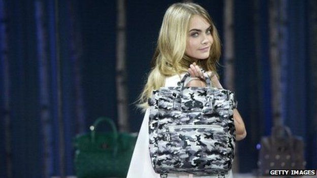 Model Cara Delevingne poses with a Mulberry handbag