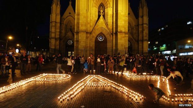 People light candles during a peace vigil in Bogota