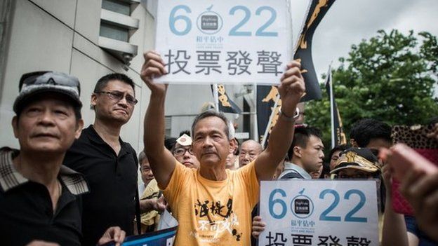Demonstrators supporting the Occupy Central movement display placards asking residents to cast ballots for the 22 June during a protest outside Beijing's representative office in Hong Kong, on 11 June.