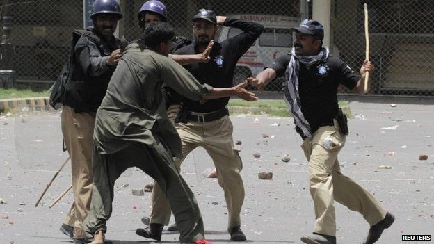 Policemen beat and detain a supporter of Muhammad Tahirul Qadri, Sufi cleric and leader of political party Pakistan Awami Tehreek, during a protest in Lahore, 17 June 2014
