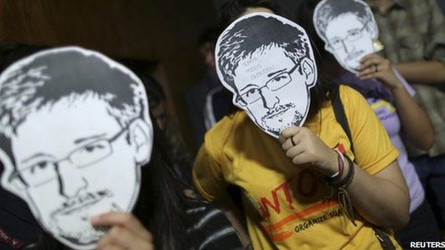 People holding Edward Snowden masks