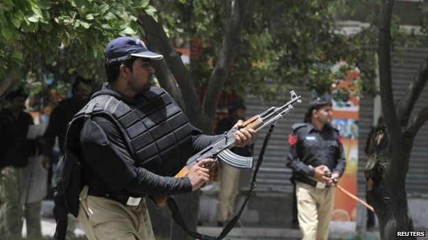 A policeman fires with his gun to disperse the supporters of Tahirul Qadri during a protest in Lahore, 17 June 2014